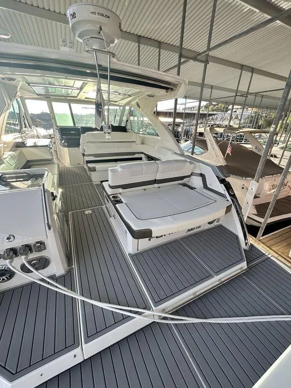 Slide: The Image of 2021 Formula 380 Super Sport Crossover yacht with spacious deck and seating under a covered dock. - 8