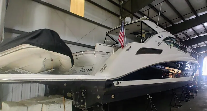 Slide: The Image of 2010 Sea Ray 540 Sundancer yacht in storage, featuring sleek design and American flag. - 1