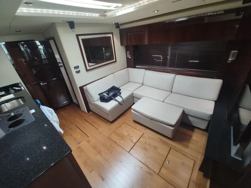 Slide: The Image of Luxurious interior of 2010 Sea Ray 540 Sundancer yacht with white leather seating and wooden flooring. - 15