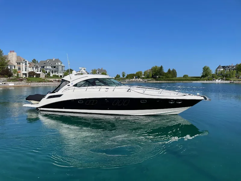 Slide: The Image of 2010 Sea Ray 540 Sundancer yacht cruising in a serene waterfront setting. - 2