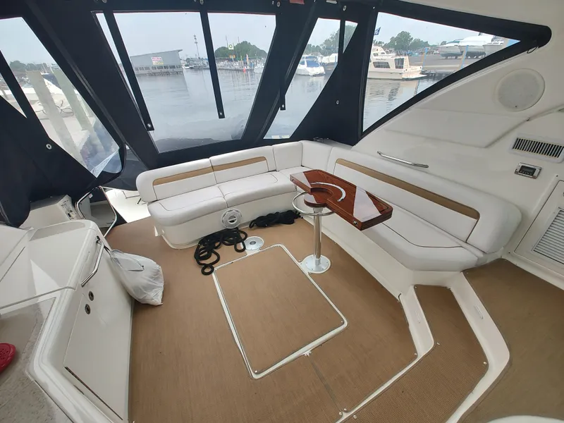 Slide: The Image of Interior of 2010 Sea Ray 540 Sundancer yacht with white seating and wooden table. - 7