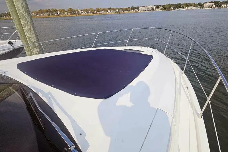 Slide: The Image of 2015 Fairline Targa 48 GT yacht bow with sunpad, docked by calm waters. - 13