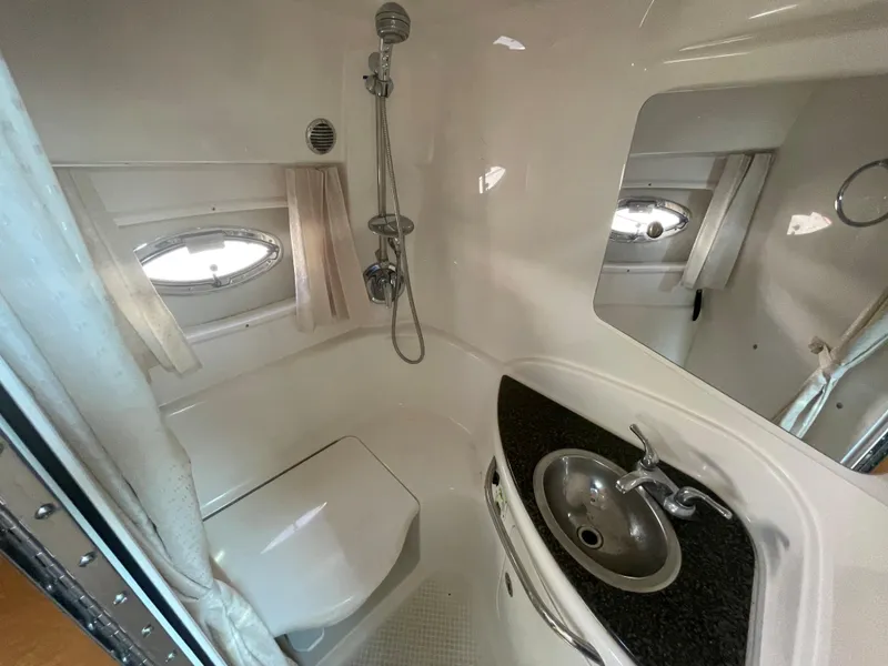 Slide: The Image of 2007 Chaparral 330 Signature boat bathroom with shower, sink, and porthole windows. - 39