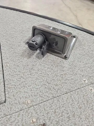 Slide: The Image of Close-up of a 2023 Lowe SD 224 boat's electrical outlet on carpeted deck. - 10