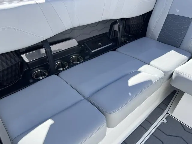 Slide: The Image of 2024 Malibu 23 MXZ boat interior seating with cup holders and storage compartments. - 10