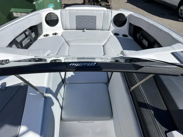 Slide: The Image of 2024 Malibu 23 MXZ boat interior with white and gray seating. - 11
