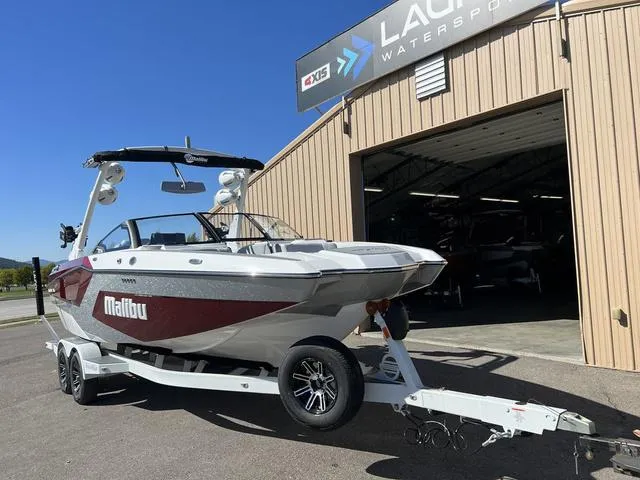 Slide: The Image of 2024 Malibu 23 MXZ boat on trailer outside Launch Watersports building. - 3