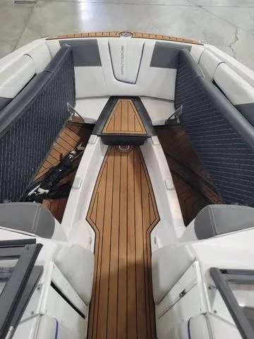 Slide: The Image of 2015 Nautique G23 boat interior with teak flooring and cushioned seating. - 10