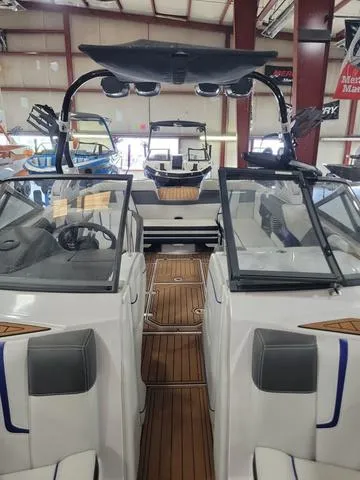 Slide: The Image of 2015 Nautique G23 boat interior with teak flooring and dual consoles. - 11
