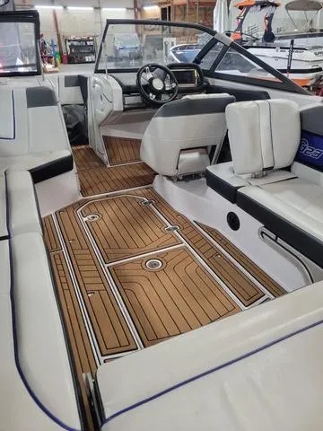 Slide: The Image of 2015 Nautique G23 boat interior with teak flooring and white seating. - 7