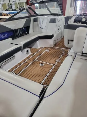 Slide: The Image of 2015 Nautique G23 boat interior with teak flooring and white leather seats. - 8