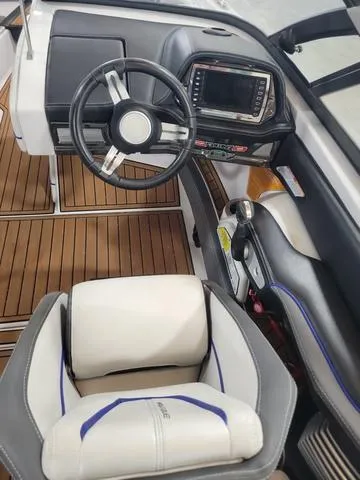Slide: The Image of 2015 Nautique G23 boat cockpit with steering wheel and control panel. - 9