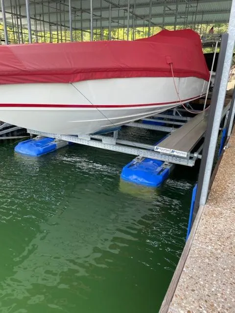 Slide: The Image of 1989 Baja 370 Force boat with red cover docked on a lift. - 2