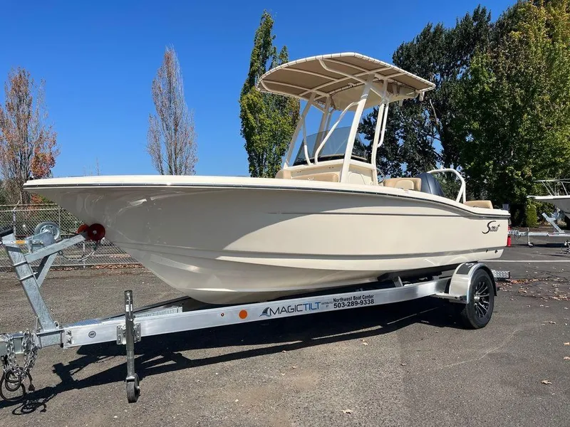 Slide: The Image of 2024 Scout 195 SF boat on a trailer in a parking lot. - 0