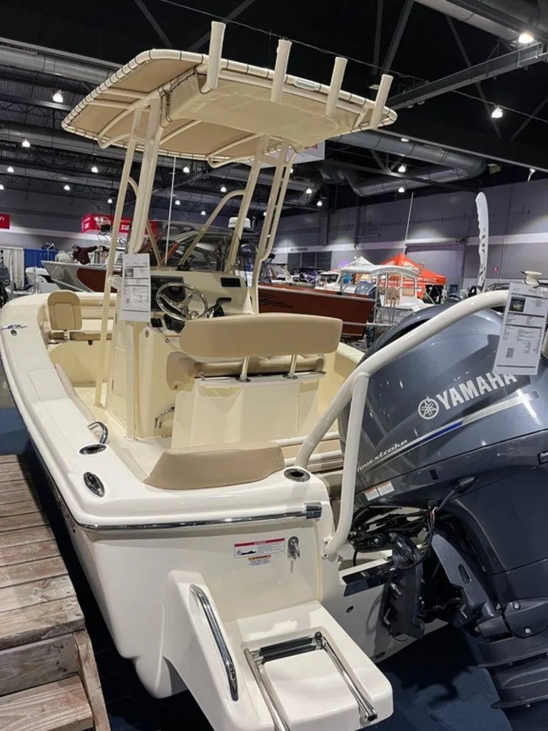 Slide: The Image of 2024 Scout 195 SF boat with Yamaha outboard motor at indoor boat show. - 2