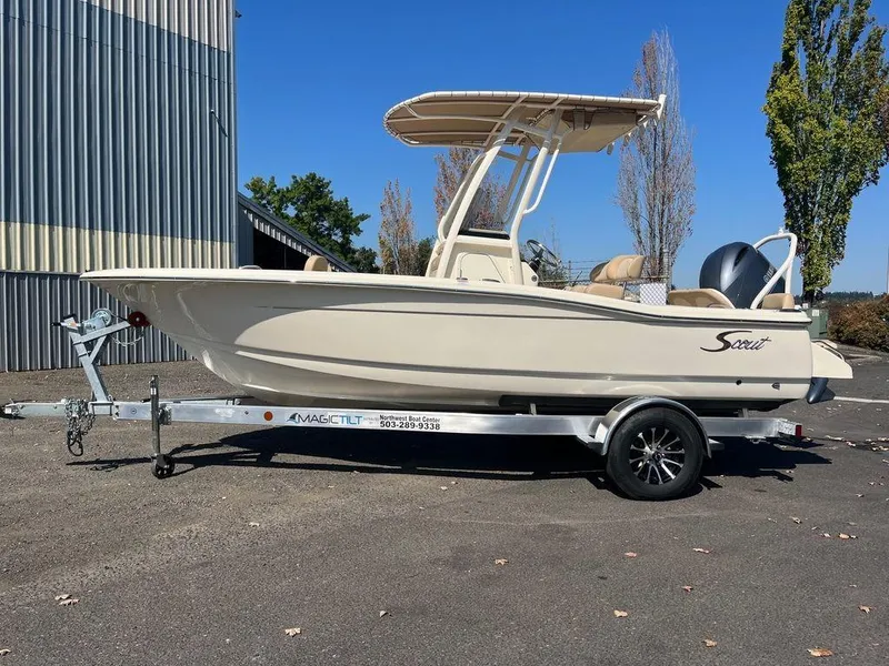 Slide: The Image of 2024 Scout 195 SF boat on a Magic Tilt trailer, parked outdoors. - 5