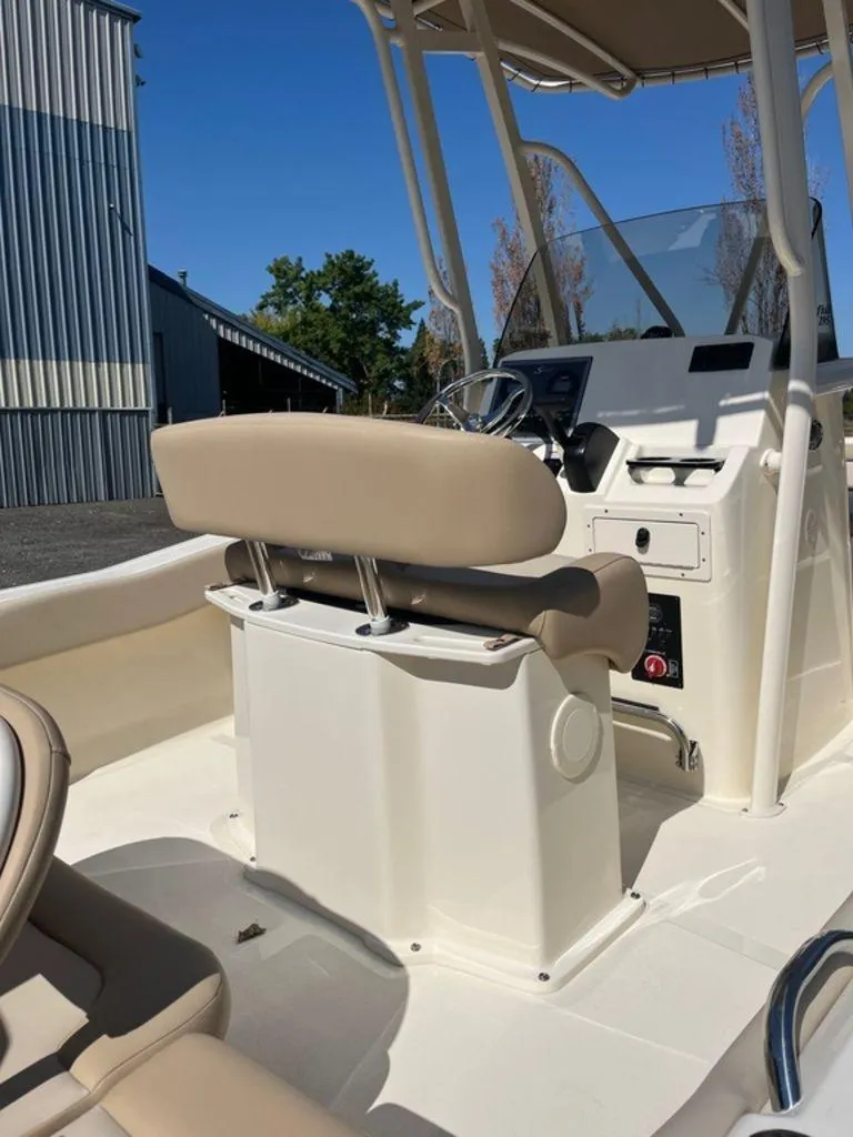 Slide: The Image of 2024 Scout 195 SF boat interior with beige seating and control console. - 8