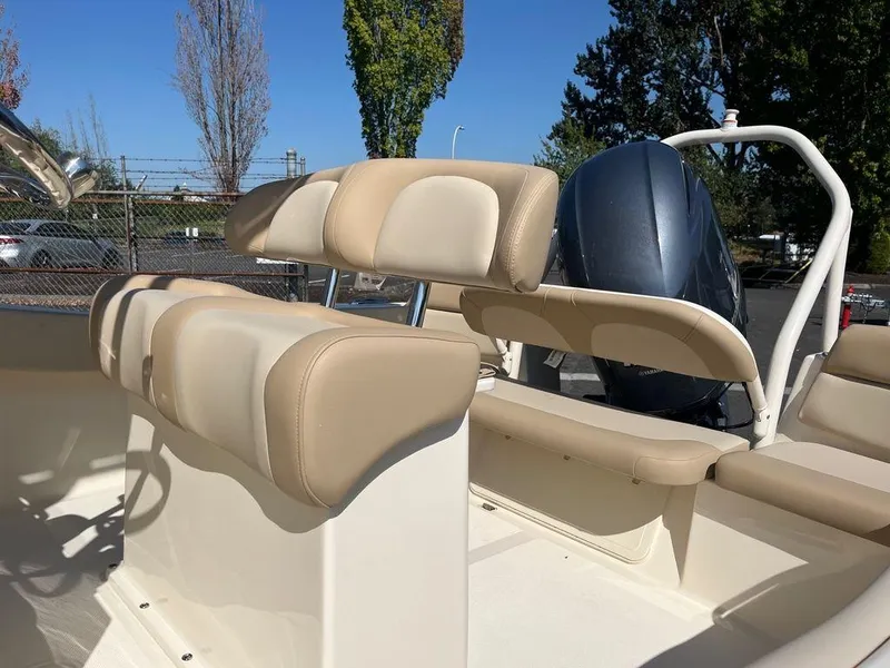Slide: The Image of 2024 Scout 195 SF boat interior with beige seating and outboard motor. - 9