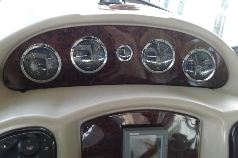 Slide: The Image of Dashboard of a 2002 Sea Ray 320 Sundancer boat with gauges and controls. - 11
