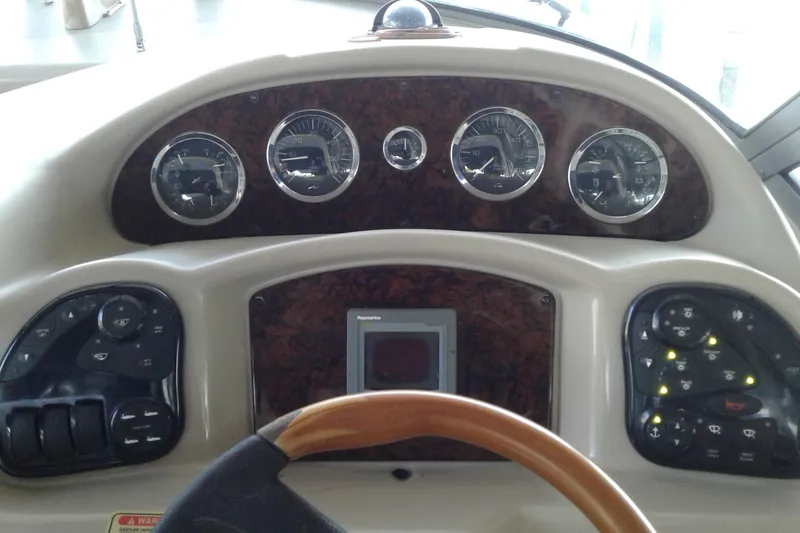 Slide: The Image of Dashboard of a 2002 Sea Ray 320 Sundancer boat with gauges and controls. - 12