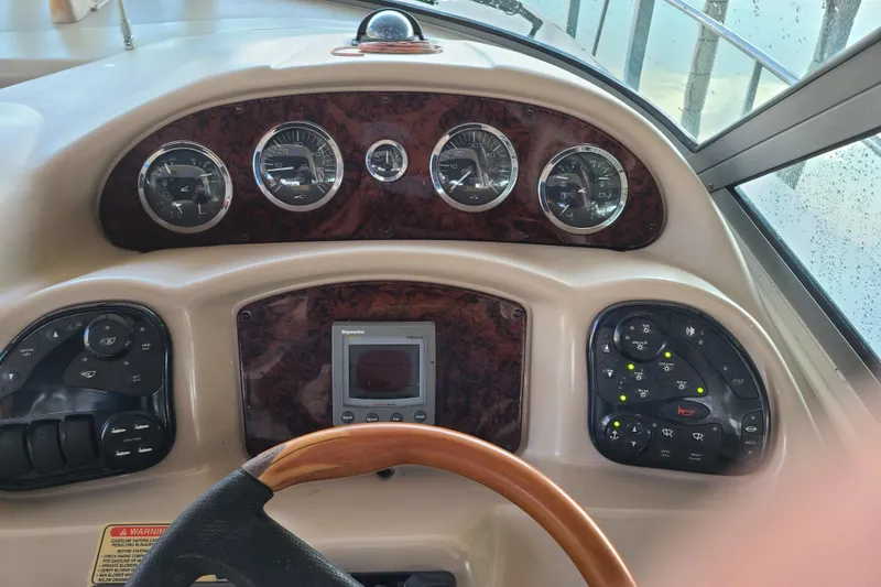 Slide: The Image of Dashboard of a 2002 Sea Ray 320 Sundancer boat with gauges and controls. - 14