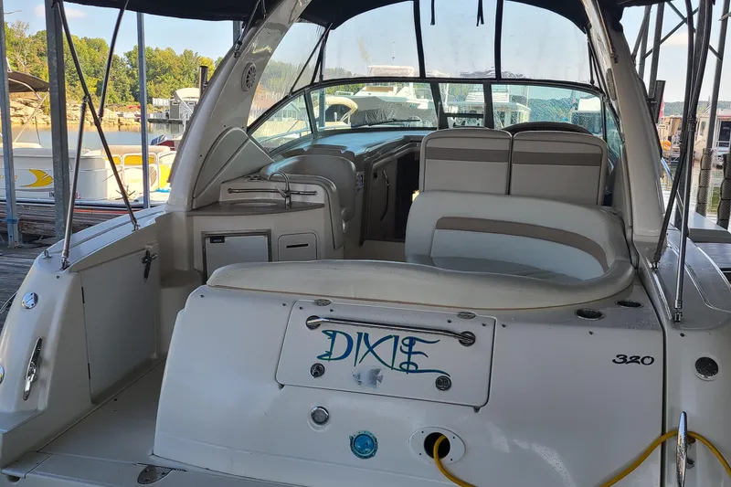 Slide: The Image of 2002 Sea Ray 320 Sundancer boat docked, rear view with seating and DIXIE nameplate. - 24