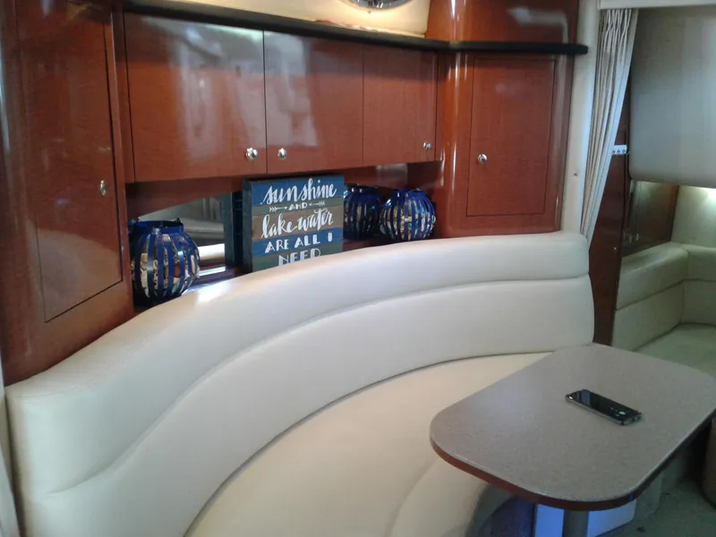 Slide: The Image of Interior of 2002 Sea Ray 320 Sundancer with curved seating and wooden cabinets. - 34