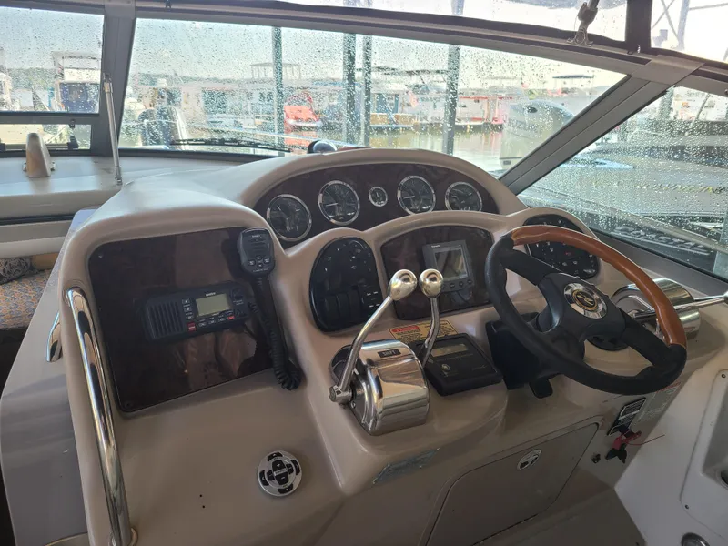 Slide: The Image of 2002 Sea Ray 320 Sundancer helm with steering wheel, gauges, and controls. - 36