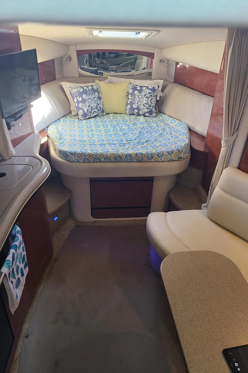 Slide: The Image of Interior cabin of a 2002 Sea Ray 320 Sundancer with bed, TV, and seating area. - 37