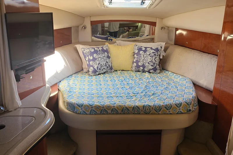 Slide: The Image of 2002 Sea Ray 320 Sundancer cabin with bed, pillows, TV, and skylight. - 38