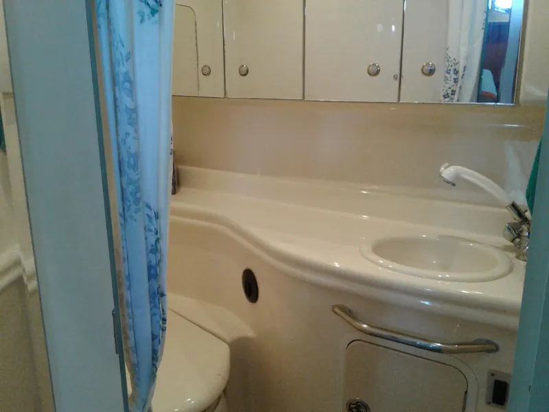 Slide: The Image of 2002 Sea Ray 320 Sundancer bathroom with sink, toilet, and storage cabinets. - 39
