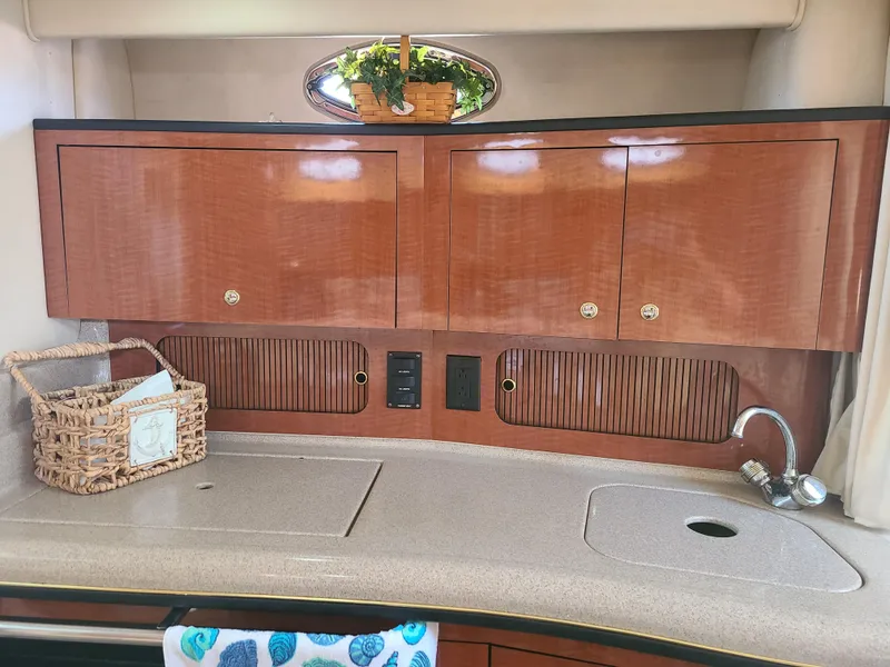 Slide: The Image of Interior kitchen area of a 2002 Sea Ray 320 Sundancer boat with wooden cabinets. - 41
