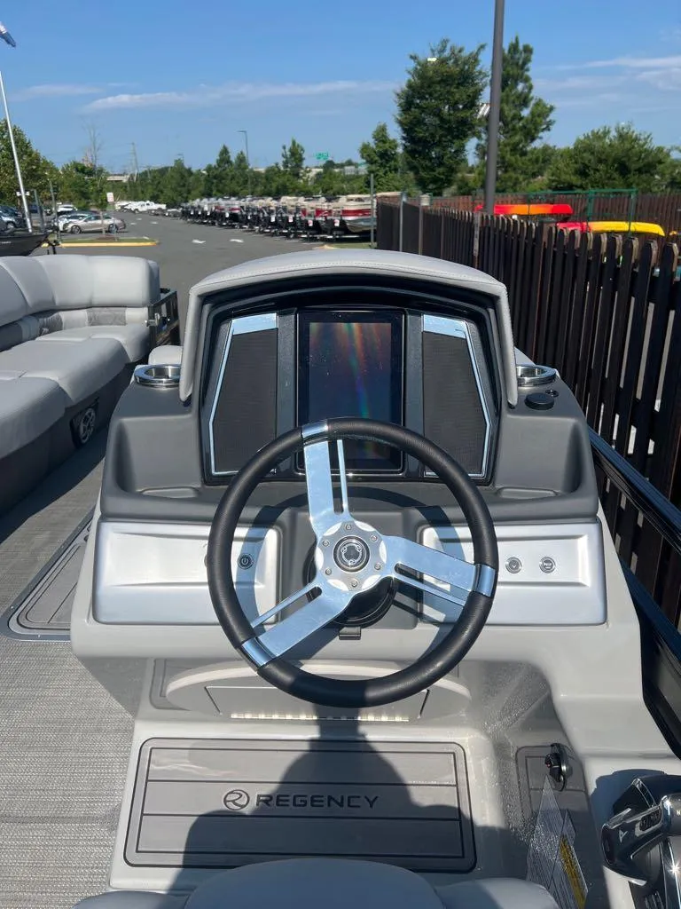 Slide: The Image of 2023 Regency 250 LE3 boat dashboard with steering wheel and control panel. - 8