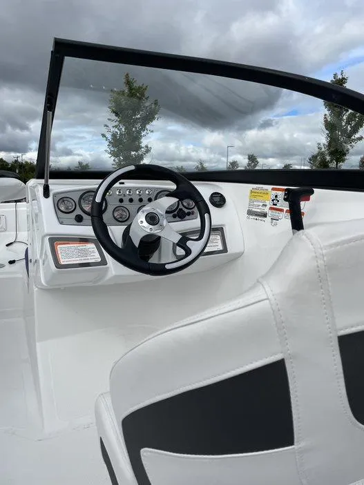 Slide: The Image of 2024 Tahoe 185 S boat dashboard and steering wheel under cloudy sky. - 7