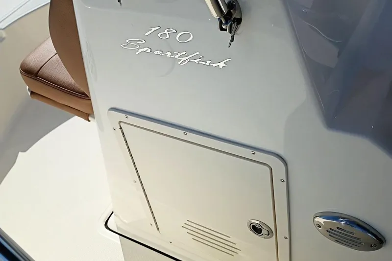 Slide: The Image of 2026 Pioneer 180 Sportfish boat console with storage compartment and seating. - 10