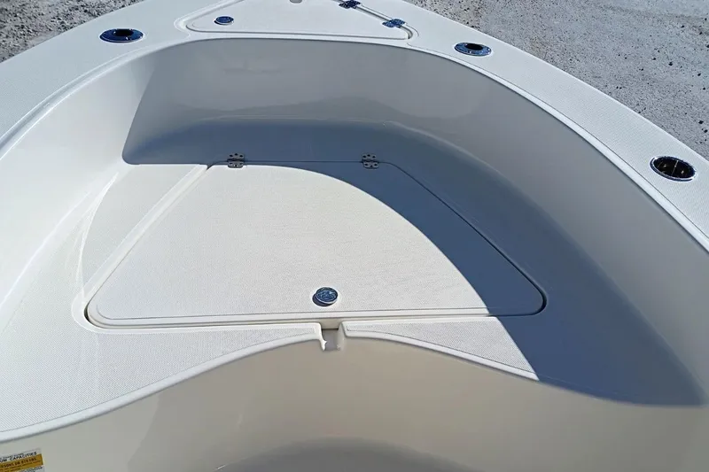 Slide: The Image of 2026 Pioneer 180 Sportfish boat deck with storage compartment and cup holders. - 13