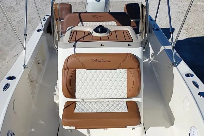 Slide: The Image of 2026 Pioneer 180 Sportfish boat interior with brown and white cushioned seating. - 19