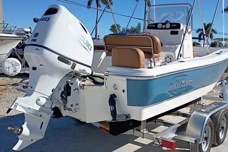 Slide: The Image of 2026 Pioneer 180 Sportfish boat with Suzuki outboard motor on a trailer. - 2
