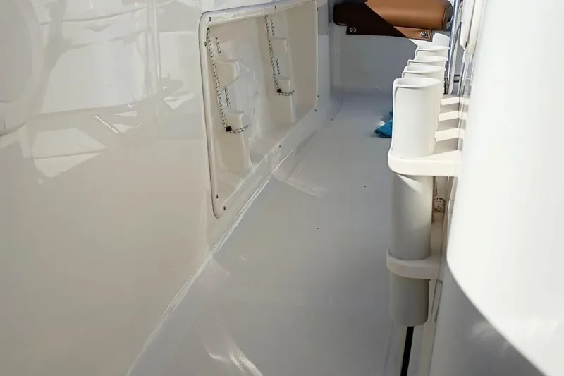 Slide: The Image of 2026 Pioneer 180 Sportfish boat interior with rod holders and storage compartments. - 21