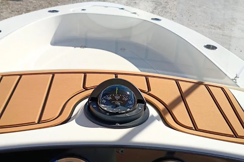 Slide: The Image of 2026 Pioneer 180 Sportfish boat dashboard with compass and wooden paneling. - 9