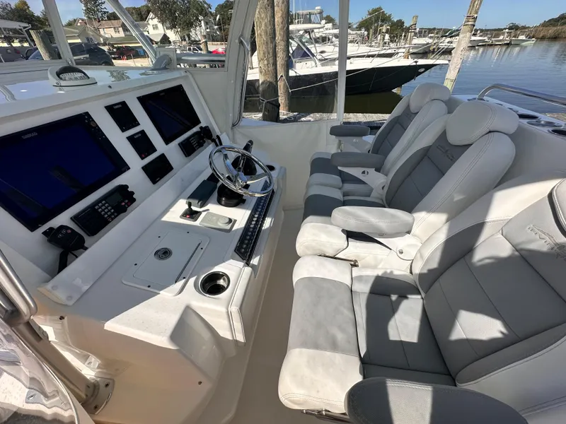 Slide: The Image of 2017 Invincible 42 Center Cabin boat interior with modern helm and comfortable seating. - 16