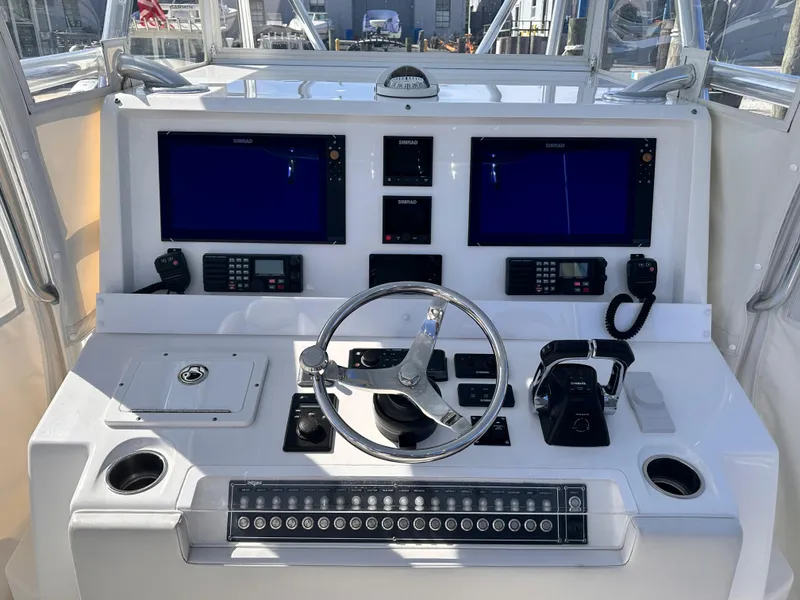 Slide: The Image of 2017 Invincible 42 Center Cabin boat helm with dual screens and navigation controls. - 18