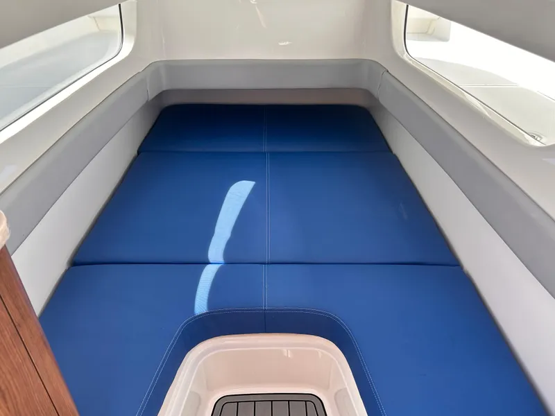 Slide: The Image of 2017 Invincible 42 Center Cabin interior with blue cushioned seating. - 28