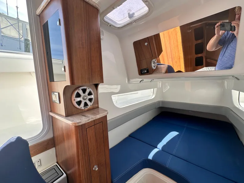 Slide: The Image of Interior cabin of a 2017 Invincible 42 Center Cabin boat with blue seating and wooden cabinetry. - 29