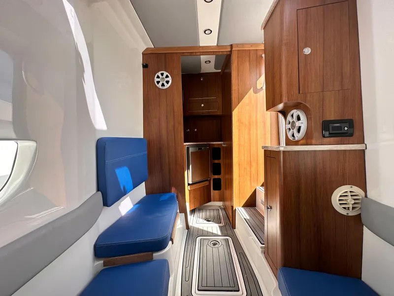 Slide: The Image of 2017 Invincible 42 Center Cabin interior with wooden cabinetry and blue seating. - 30