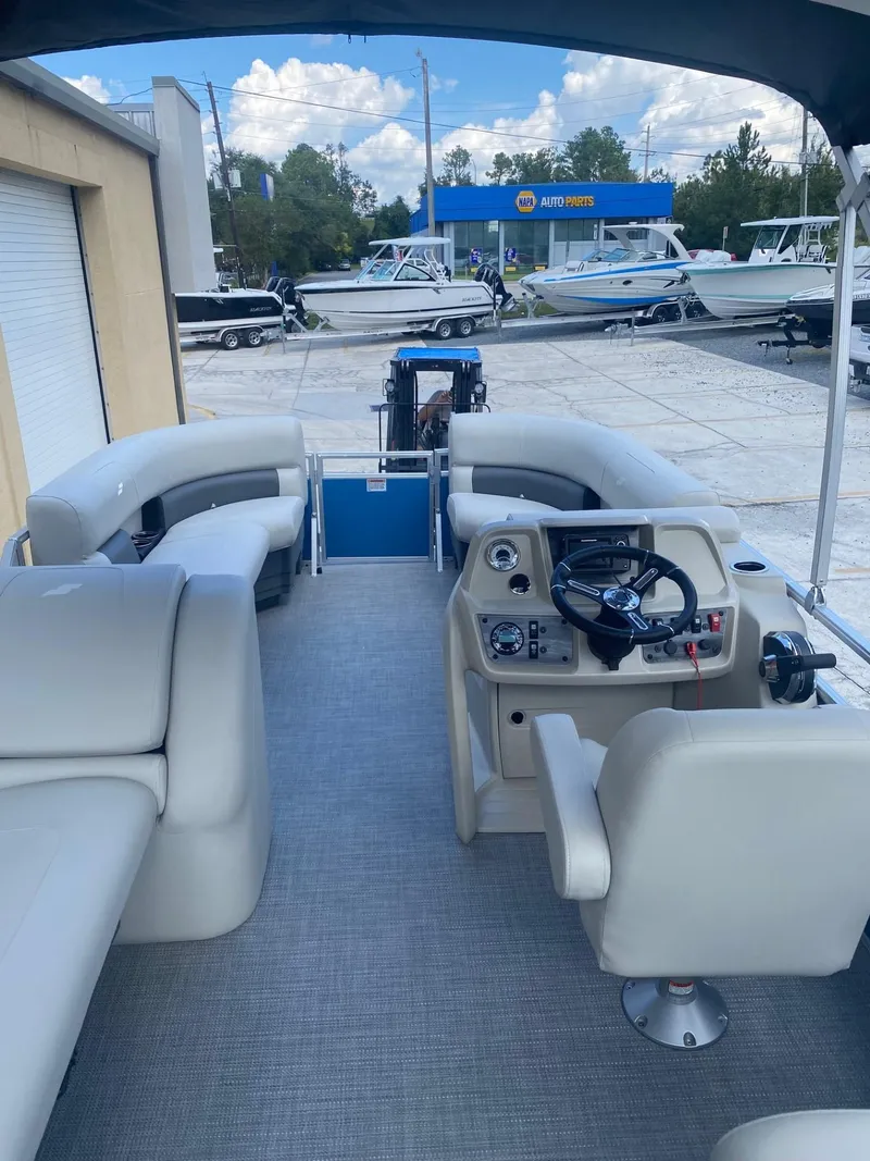 Slide: The Image of 2024 Starcraft LX 20 R pontoon boat interior with helm and seating. - 11