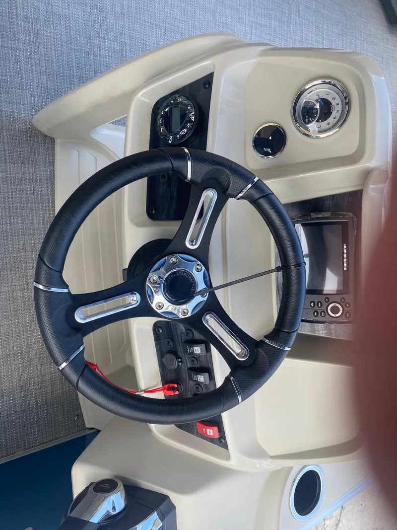 Slide: The Image of 2024 Starcraft LX 20 R boat steering console with gauges and controls. - 12