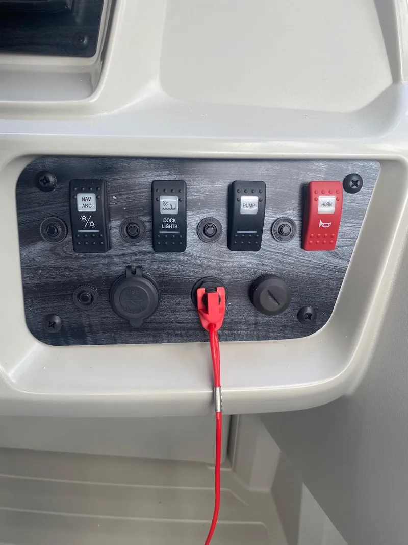 Slide: The Image of Control panel of 2024 Starcraft LX 20 R boat with switches and safety lanyard. - 13