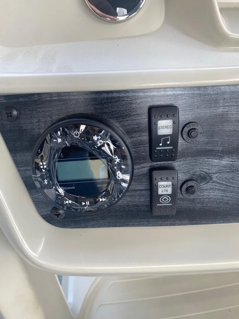 Slide: The Image of Control panel of 2024 Starcraft LX 20 R boat with switches and gauge. - 14