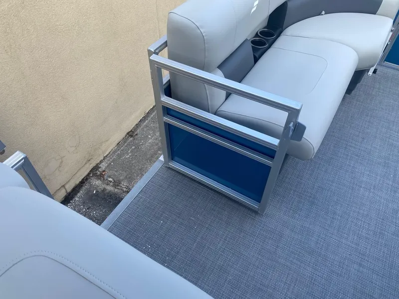 Slide: The Image of 2024 Starcraft LX 20 R pontoon boat interior with gray seating and blue accents. - 15